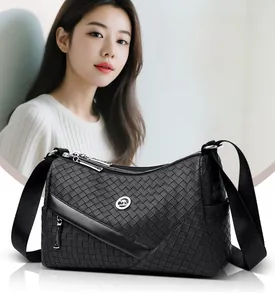Detail of woven black shoulder bag with circular kangaroo logo and silver metal zipper