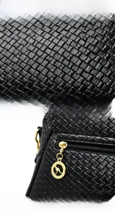 Close-up of black woven leather texture and golden zipper with kangaroo charm detail