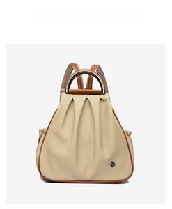 Detail view of beige canvas backpack with brown leather straps and black flower metal logo