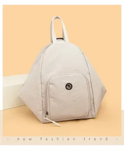 Détail d'un sac à dos en nylon gris avec coutures triangulaires et logo kangourou