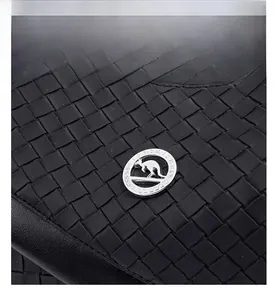 Detailed macro view of black woven leather texture and silver circular kangaroo metal logo