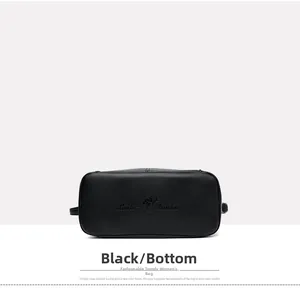 Detailed view of black litchi grain leather bag bottom with embossed kangaroo logo