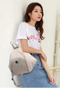 Détail d'un sac à dos multifonctionnel crème avec logo sur modèle en situation réelle