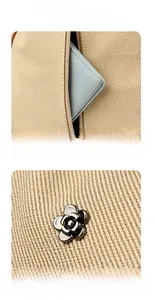 Detail view of beige canvas bag with metal flower hardware and rear zipper pocket