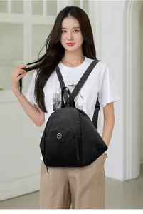 Détail d'un sac à dos noir en nylon avec logo kangourou porté par un mannequin de face