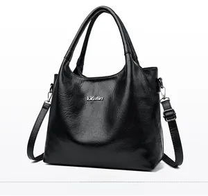 Détail du sac en cuir grainé noir avec logo Yifutin et finitions métalliques argentées