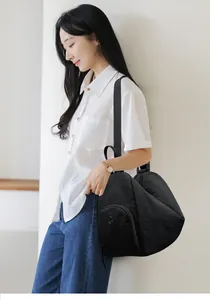 Détail d'un sac à dos en nylon noir avec poche latérale zippée et logo en métal poli