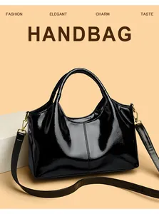 Detailansicht der schwarzen Lackleder-Handtasche mit goldfarbenen Metallschnallen und Griffen