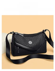 Detail of black woven pattern PU leather bag with metal kangaroo logo and nylon strap
