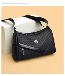 Detail of woven leather texture and kangaroo emblem on black crossbody shoulder bag