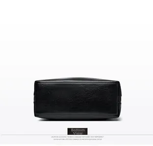 Détail de la base rectangulaire et des coutures fines sur un sac cabas en cuir noir