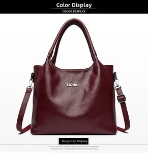 Détail du sac fourre-tout bordeaux avec texture en cuir grainé et logo en argent