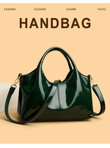 Detail der dunkelgrünen Lackleder-Handtasche mit goldenen Beschlägen und Hochglanz