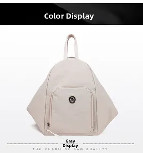 Vue détaillée d'un sac à dos gris en nylon avec design triangulaire et poche zippée