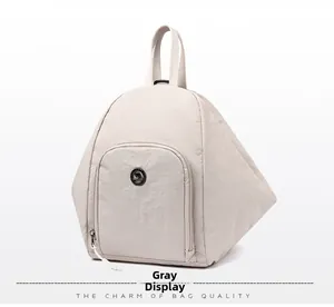 Vue détaillée du sac à dos en nylon gris avec motif géométrique et logo métallique rond