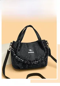 Close-up of black snakeskin texture handbag with silver kangaroo logo and metal chain detail