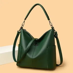 Dark green leather bucket bag with metal kangaroo logo and adjustable shoulder strap