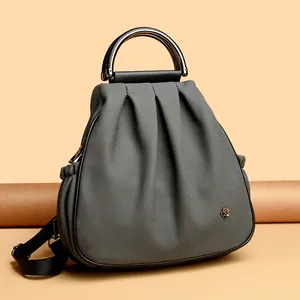 Dark gray pleated trapezoid dual-use backpack with a gold flower logo and metal handle