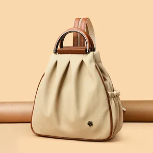 Beige canvas and brown leather multi-way backpack with metal flower detail