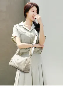 Detailed view of beige woven leather crossbody bag with broad fabric shoulder strap