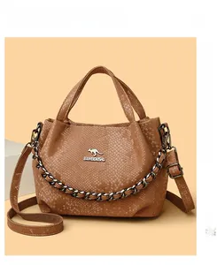 Detail of snake embossed texture and kangaroo logo on brown leather bucket bag