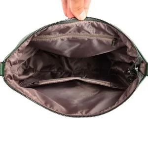 Deep green leather bucket bag with spacious brown logo-embossed lining and inner zip pocket