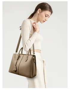 Detailed view of the earth-tone leather tote bag with elegant handles and fine texture