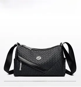Detail of black woven leather crossbody bag featuring a golden kangaroo metal logo