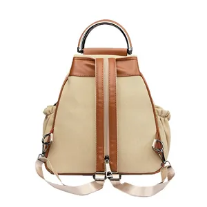Beige canvas backpack with leather trim and round metal handle for women's casual style