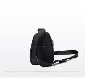 Detail of black woven leather crossbody bag showing dual zip pockets and nylon strap