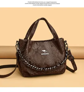 Close-up of dark brown snakeskin texture handbag with chain detail and brand logo