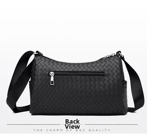 Back view of black woven crossbody bag with rear zipper pocket and wide strap