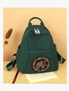 Detalle de mochila de nailon resistente al agua con elegante diseño de elefante en pedrería