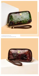 Detail of vintage embossed peony pattern on leather clutch wallet with gold accents