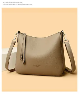 Detail of khaki leather bucket bag with LYYZ brand logo and side tassel decoration