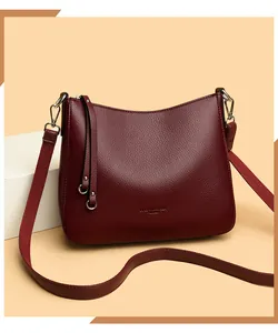 Close-up of wine red pebbled leather texture and embossed logo on bucket bag