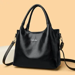 Sac fourre-tout minimaliste en cuir noir vintage avec logo argenté et bandoulière réglable