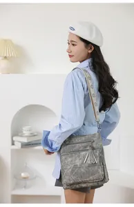 Detail of vintage grey quilted bucket bag with double tassels and ethnic jacquard strap