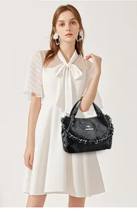 Detail of black snakeskin texture handbag with silver kangaroo logo and metal chain