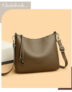 Detailed view of brown litchi grain leather texture and silver hardware on hobo bucket bag