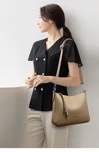 Detail of apricot pebbled leather bucket bag with silver hardware and shoulder strap