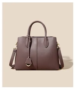 Detail of lychee pattern leather tote bag with round handles and gold pendant