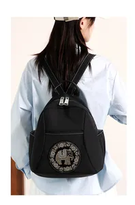 Detalle de mochila de nailon negro impermeable con un brillante motivo de elefante en strass