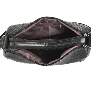 Top view of black woven crossbody bag with dual zipper compartments and brown lining