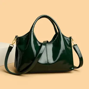 Glänzende dunkelgrüne Lackleder-Handtasche mit goldenen Details und Schultergurt