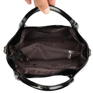 Glänzende schwarze Lacklederhandtasche mit organisierten Innenfächern und braunem Futter