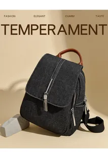 Detail of black denim backpack with tassel metal chain and premium leather handle strap