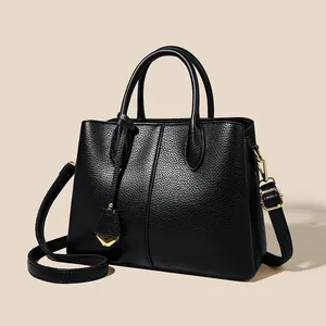 Minimalist black lychee pattern leather tote bag with golden hardware and shoulder strap