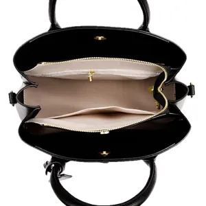 Minimalist black pebble leather tote bag with three compartments and gold hardware detail