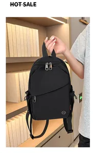 Close-up of black nylon backpack featuring multi-zipper pockets and side drawstring detail